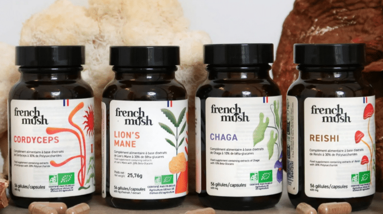 Boîte de gélules French Mush posée sur une surface en bois, étiquette visible, avec le détail de la composition des cinq champignons bio cultivés en France