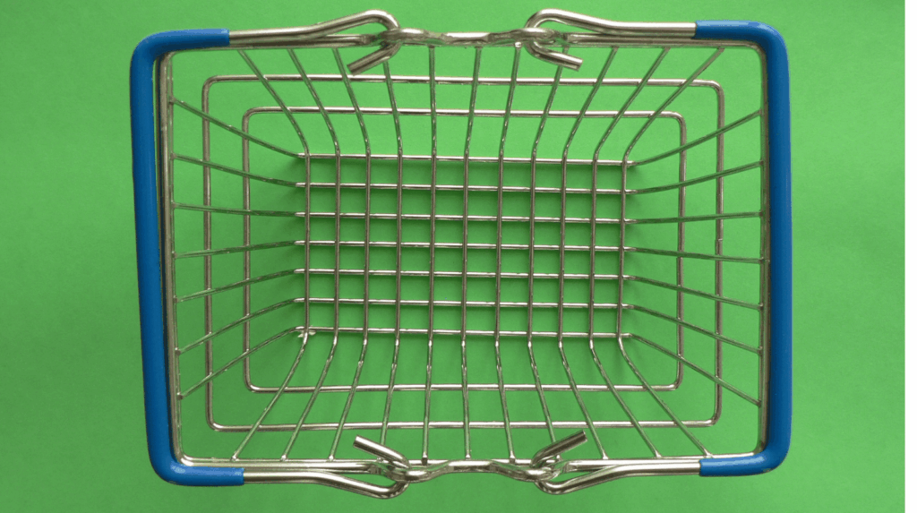 Ordinateur portable ouvert sur un site de courses en ligne avec panier rempli de produits alimentaires bio, fruits et légumes posés sur une table de cuisine pour illustrer les tests de services de courses en ligne et de producteurs.