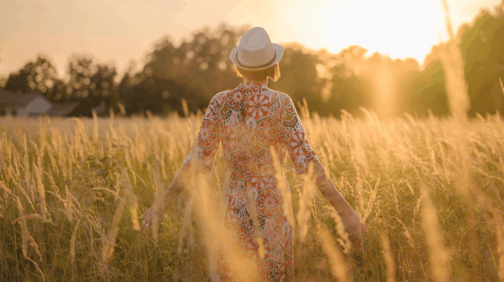 Femme examinant un vêtement sur un portant dans un dressing, observant la matière, les coutures et la coupe pour évaluer la qualité d’une marque de vêtements pour femme.