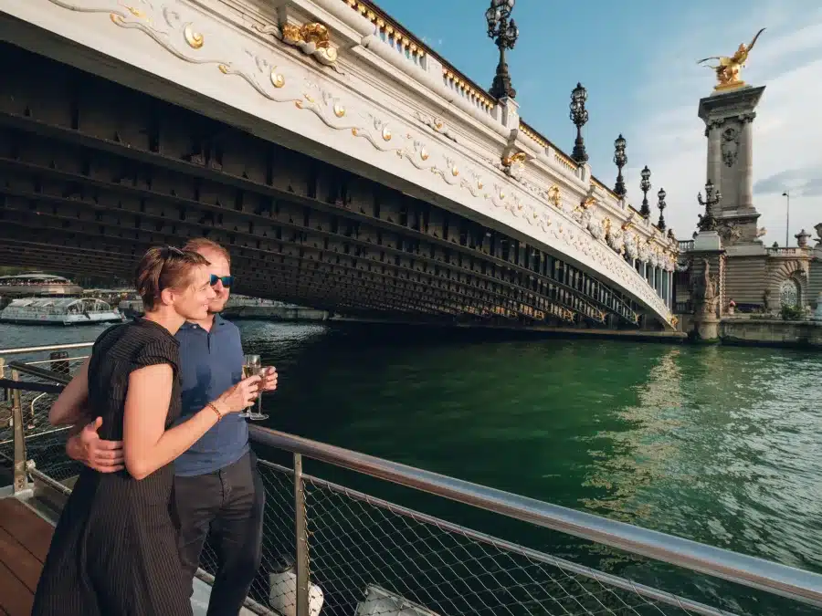 Passagers profitant d’un apéritif sur un bateau pendant une croisière au coucher du soleil sur la Seine à Paris
