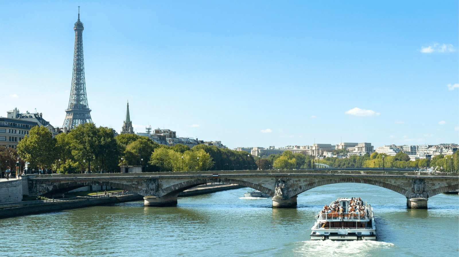 Bateau de croisière naviguant sur la Seine à Paris avec vue sur les quais et les monuments emblématiques de la capitale