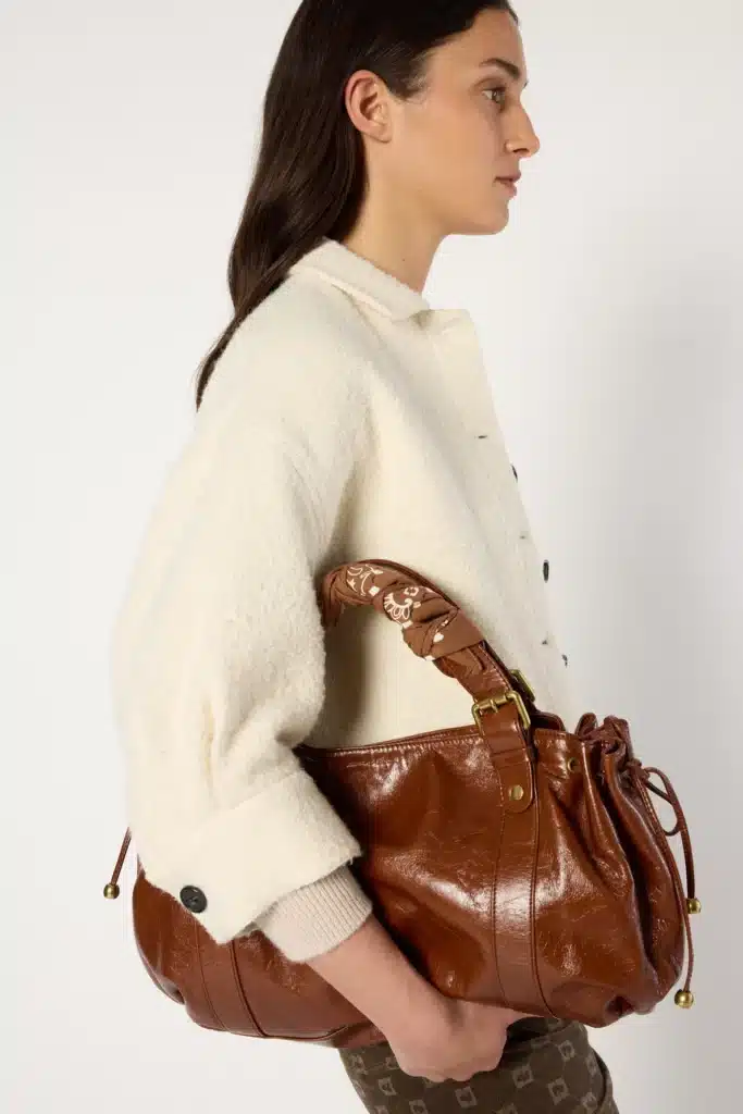 Manteau élégant Gérard Darel porté dans un look féminin chic illustrant l’idée d’un vêtement durable et intemporel pouvant rester plusieurs saisons dans un dressing.