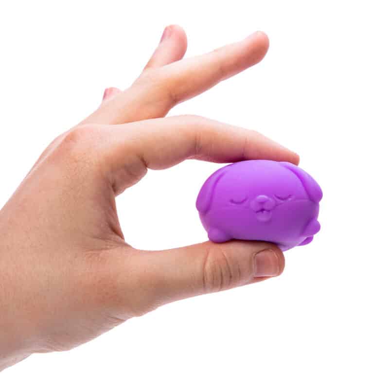 Lot de Teenie NeeDoh multicolores dans une paume montrant leur format mini discret adapté à l'usage au bureau et à l'école
