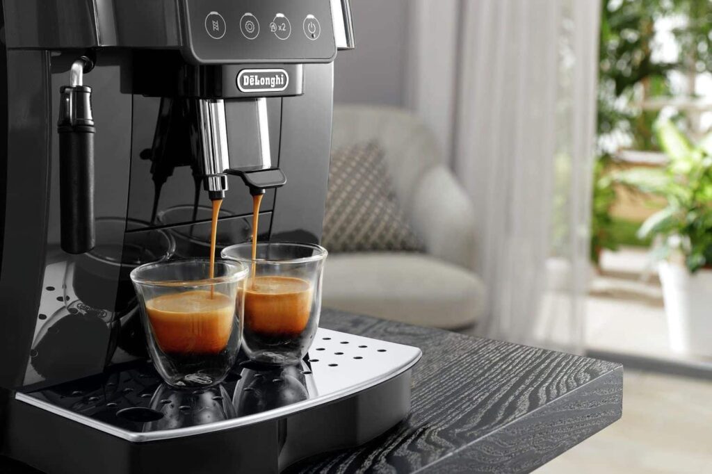 La De'Longhi Magnifica Evo en finition argent et noir posée sur un comptoir, avec sa buse vapeur manuelle visible sur le côté droit et son panneau de commandes simplifié sur la façade