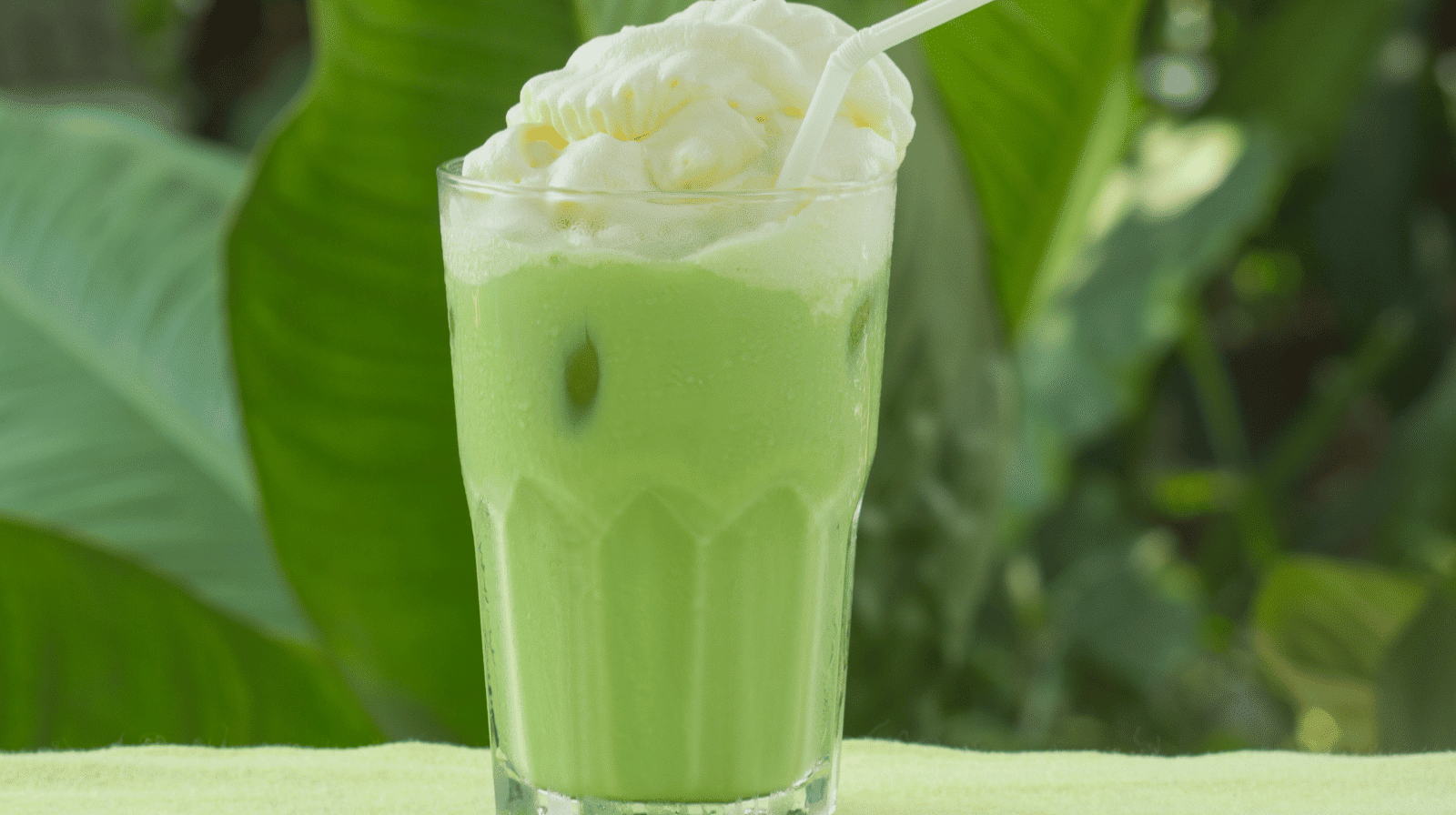 Einspänner matcha dans un verre transparent avec couche de chantilly maison et saupoudrage de poudre de matcha