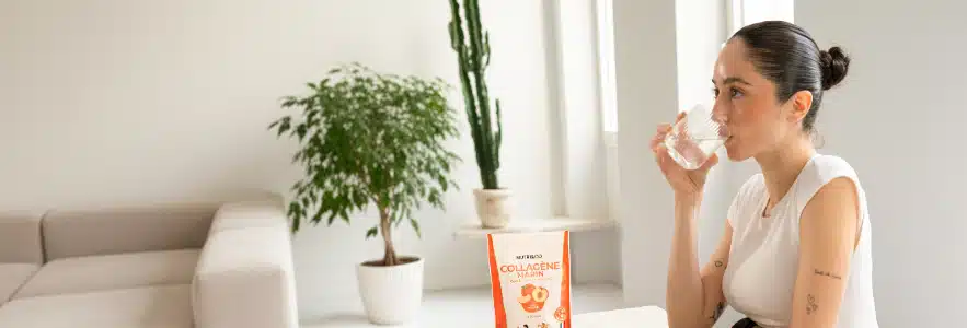 Cuillère de collagène marin Nutri&Co saveur pêche diluée dans un verre d'eau