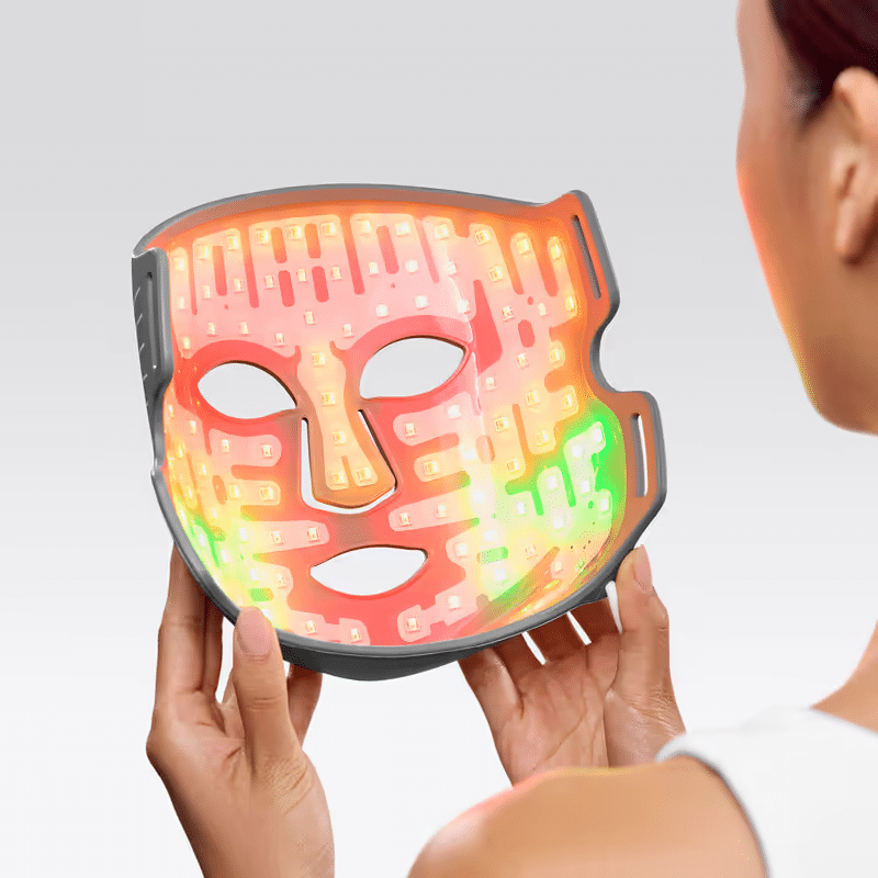 le masque LED multi-couleurs CurrentBody posé sur mon étagère de salle de bain, son contrôleur digital à côté affichant le mode complet, photographié après ma séance du matin avant de partir travailler.