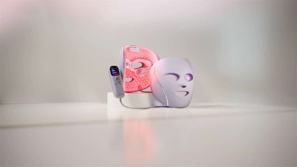 Le masque LED CryoGlow de SharkNinja, la marque qui a détrôné les spécialistes historiques du secteur grâce à son expérience industrielle héritée de ses aspirateurs et friteuses à air. Cette photo illustre ses trois longueurs d'onde, rouge, bleue et proche infrarouge, associées à un système de refroidissement InstaChill unique sur le marché, ce qui en fait selon mon comparatif la marque la plus complète pour traiter à la fois l'acné, le collagène et les poches sous les yeux en un seul appareil.