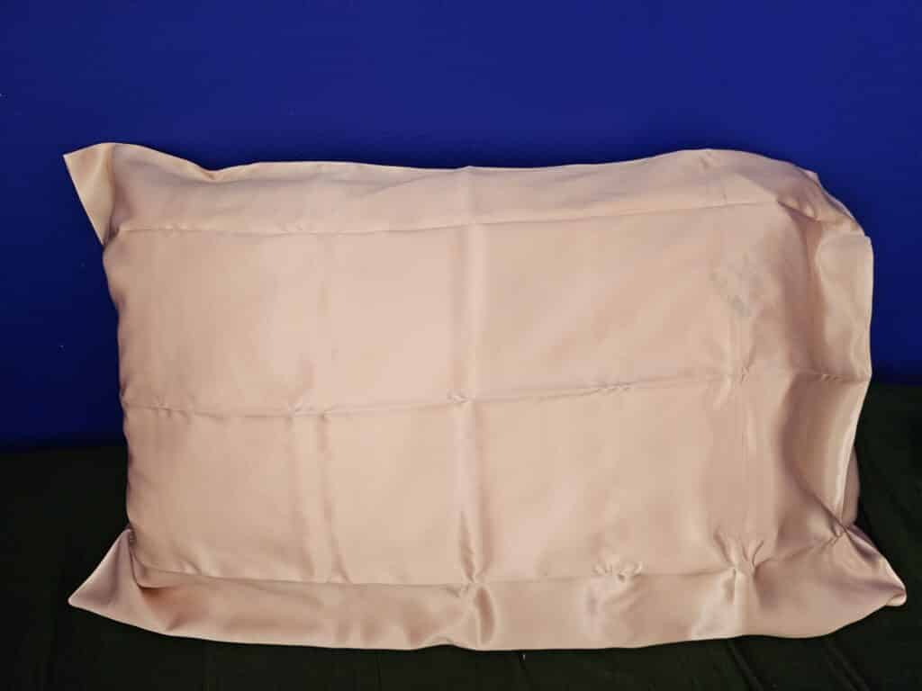 Zip latéral de l'oreiller wopilo plus entrouvert, laissant voir le cœur en mousse à mémoire de forme glissé dans la poche de garnissage en microfibre blanche.