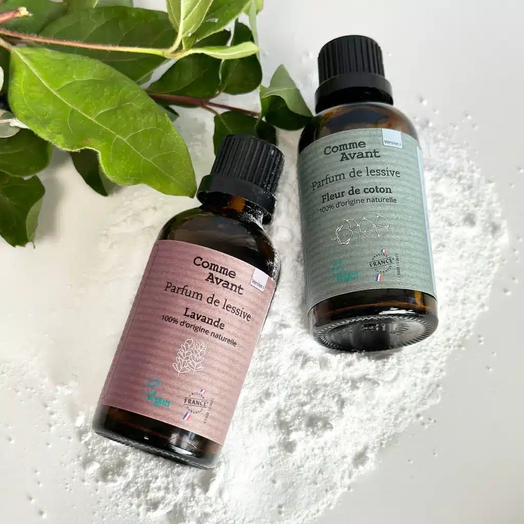 le petit flacon en verre du parfum de lessive fleur de coton, posé à côté du bac ouvert de la machine, le compte-goutte encore à la main juste avant d’ajouter quelques gouttes à la lessive.