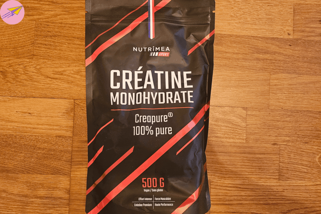 le sachet de créatine avec sa cuillère doseuse plantée dedans, posé sur mon plan de travail à côté de mon shaker vide, juste avant de préparer ma dose du jour.
