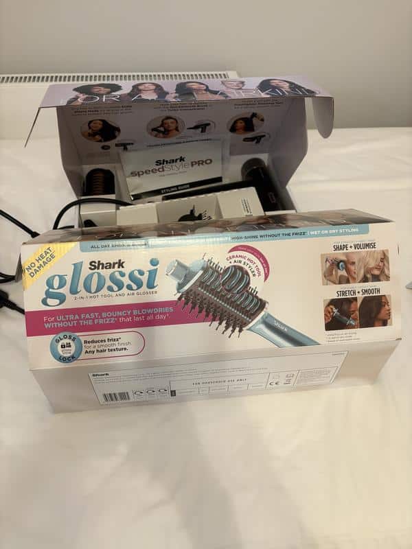 hoto de la brosse soufflante Shark Glossi posée à plat sur une serviette pour illustrer ses dimensions et son poids